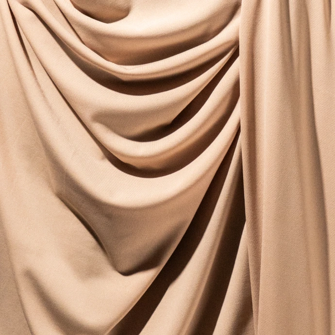 Gros plan sur la texture d'un tissu jersey premium de couleur beige.