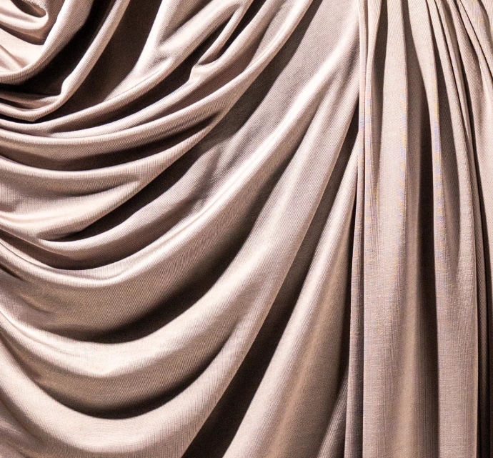 Gros plan sur la texture d'un tissu jersey liquid de couleur grisn.